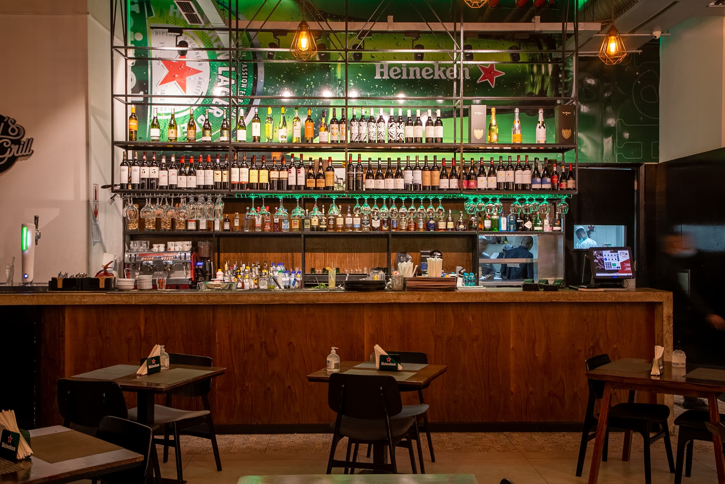 Bar com prateleiras de garrafas e néon verde