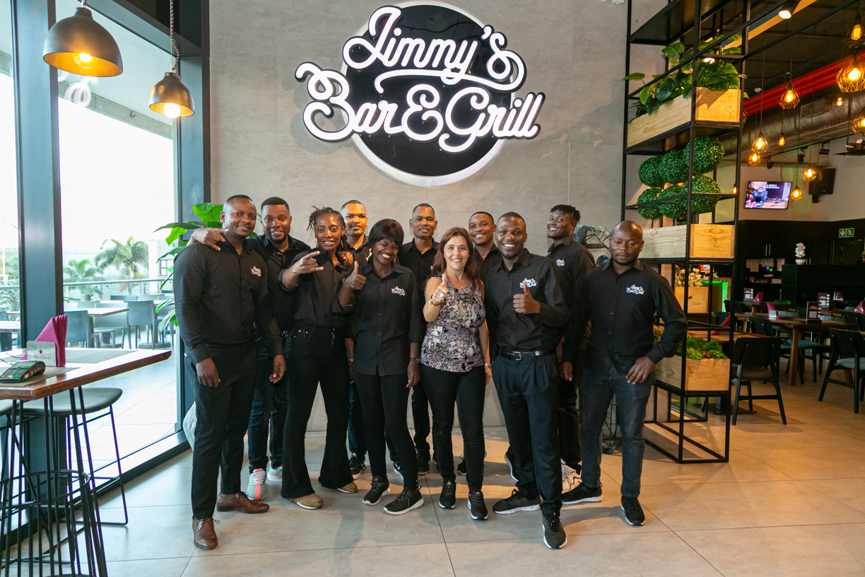 Equipa do Jimmy's Bar & Grill sob o logo néon